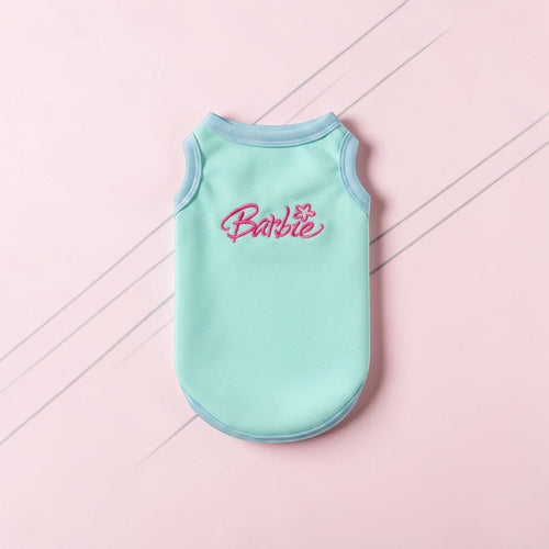 The Spoiled Pet Club Barbie tropical dog tank in sky blue with pink embroidered logo on a soft pink background.
