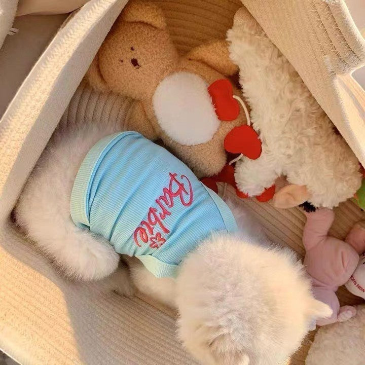 The Spoiled Pet Club light blue ribbed tank top with pink Barbie logo and floral detail on a white dog.