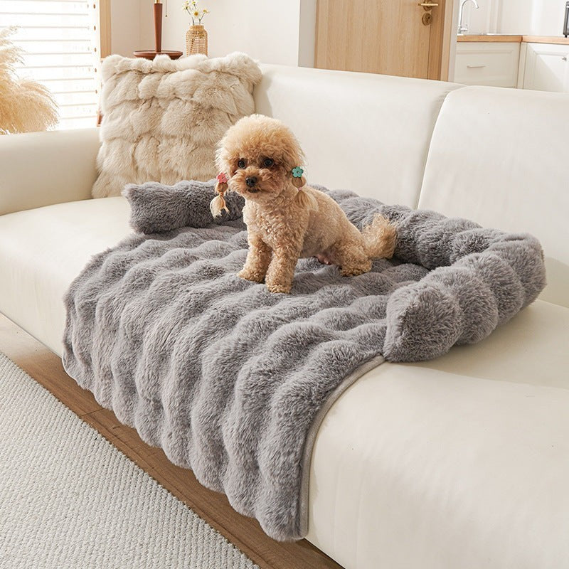 The Spoiled Pet Club grey plush couch nest with a small poodle sitting on it.