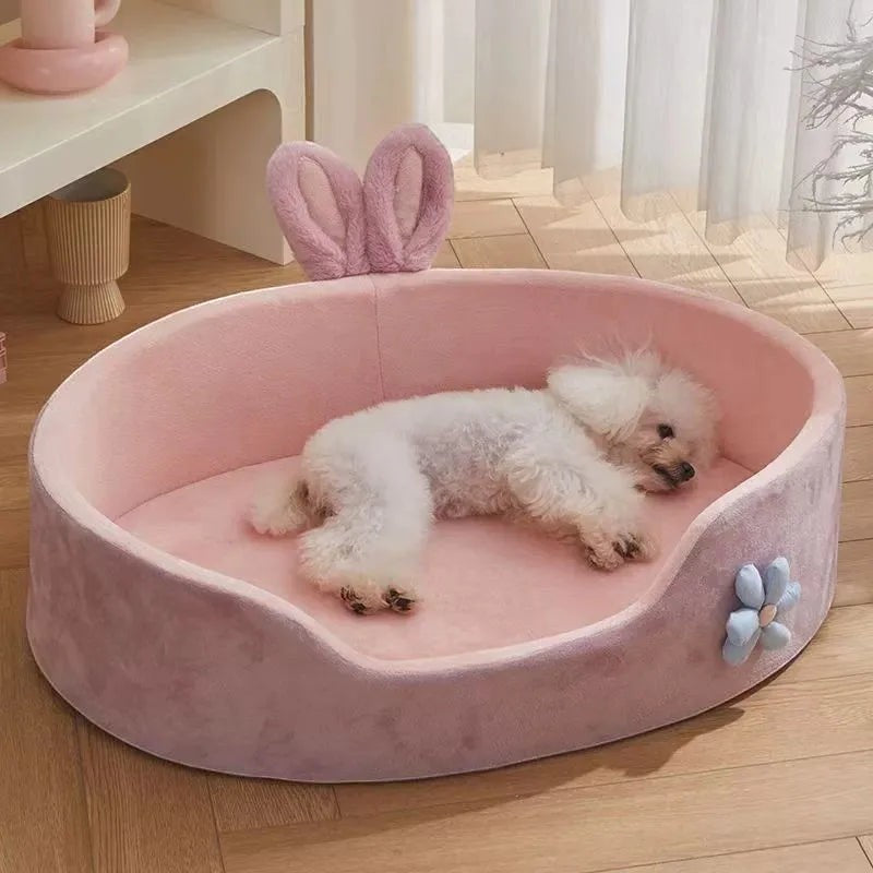 The Spoiled Pet Club pink plush dog bed with raised edges and bunny ears, featuring a small white dog.