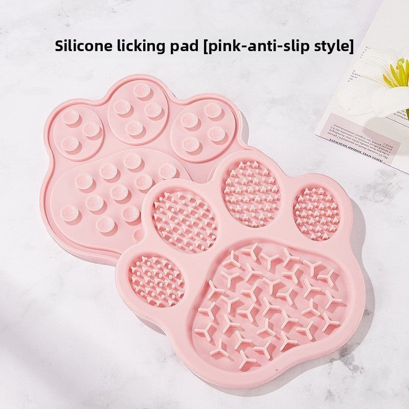 The Spoiled Pet Club pink silicone paw-shaped lick mat with suction cups for slow feeding and anti-slip stability.