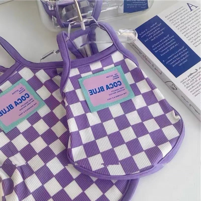 The Spoiled Pet Club purple and white checkered acrylic fiber dog tank top with a blue and pink tag.