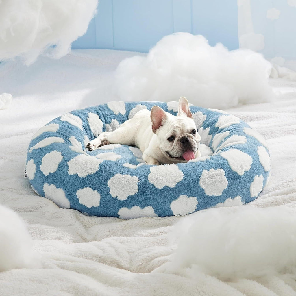 The Spoiled Pet Club round thermal pet bed with blue sky and white cloud pattern, featuring a resting French Bulldog.