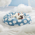 The Spoiled Pet Club round thermal pet bed in blue sky and white cloud print with a French Bulldog resting inside