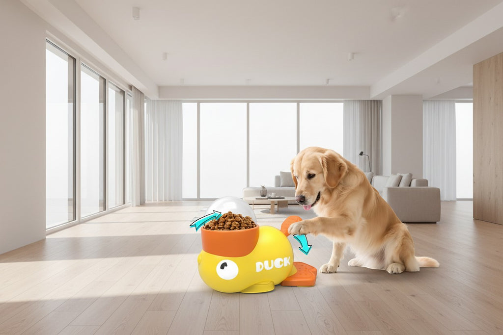 The Spoiled Pet Club Treat Me Duck treat dispenser is yellow with an orange bowl and a golden retriever interacting with it.