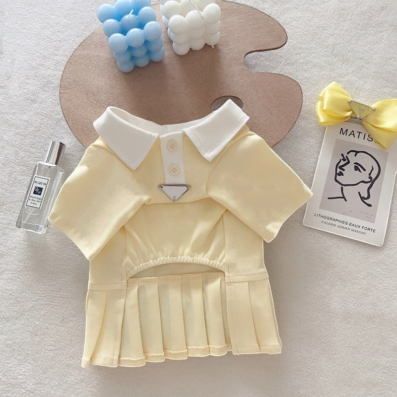 The Spoiled Pet Club yellow cotton dog dress with a white polo collar, button placket, and pleated skirt.